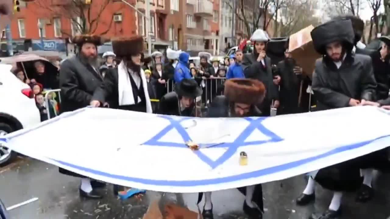 أعضاء منظمة يهودية يحرقون علم "إسرائيل" خلال تظاهرة داعمة لغزة في نيويورك الأمريكية