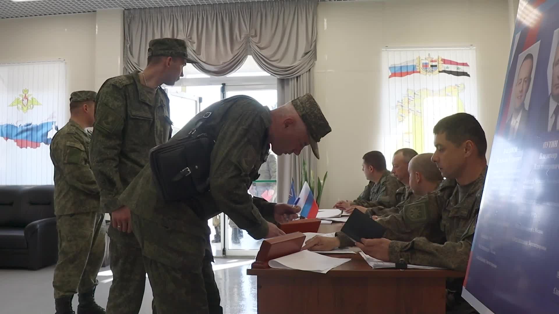 Russian military personnel cast their votes in the Russian presidential elections at the Hmeimim base